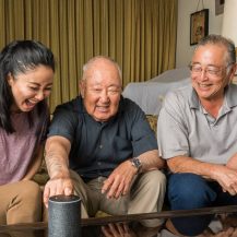 Older adult using smarthome tech with other family members