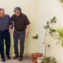 older adult being assisted by caregivers