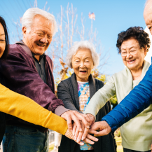 older adults putting hands together
