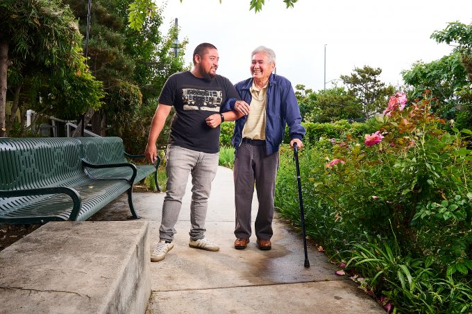two men speaking with linked arms