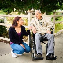 man in wheelchair speaking with woman