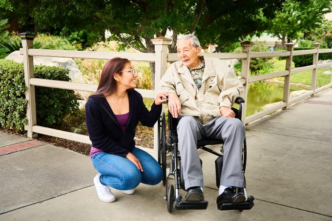 man in wheelchair speaking with woman