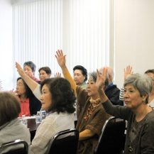 older adults raising their hands