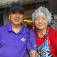 a woman in a hairnet and a man in a hat smiling at the camera