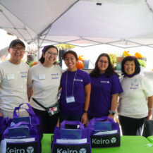 group of people smiling behind a green table