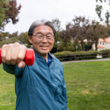 man in blue sport coat holding a red weight