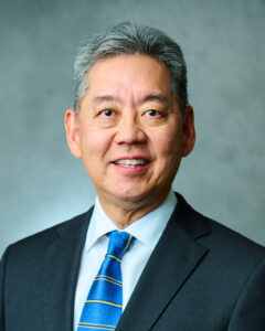 man in blue gray suit with a light blue tie