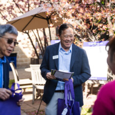 Gerald Iseda smiling while handing out program booklets