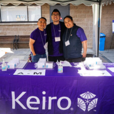 conference volunteers smiling at Keiro table