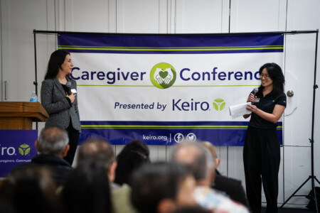 Roxy Kirakosyan and Keiro staff on stage with Caregiver Conference banner in background