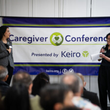 Roxy Kirakosyan and Keiro staff on stage with Caregiver Conference banner in background
