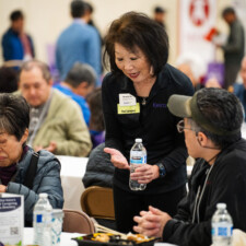Beverly Ito talking to conference attendee at table