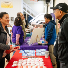 conference attendee talking to resource fair vendor at table