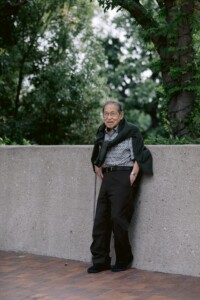 older man leaning against the wall posing