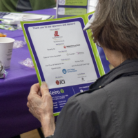 woman holding a program booklet with list of sponsors