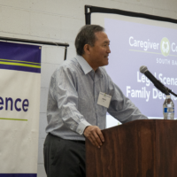 man in blue and white button up talking on a podium