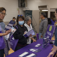 women talking with the another woman by a purple a table