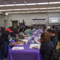 people sitting at tables listening to presentation