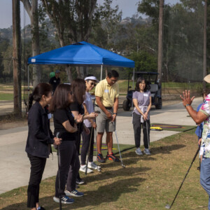 a man in a Hawaiian shirt instructing to a group of people