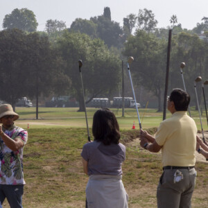 a group of people holding their golf clubs up