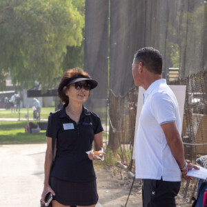 a woman in black talking to a man in white