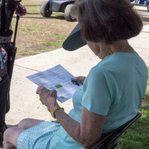 a woman in blue reading a program booklet