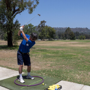 a man in blue swinging at a golf ball