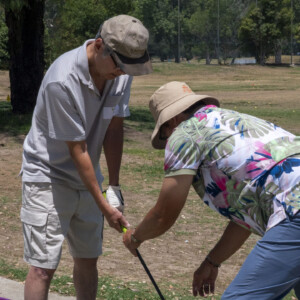 a man in a Hawaiian shirt instructing to a man in gray