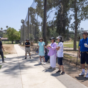 a man in a Hawaiian shirt talking to a group of people