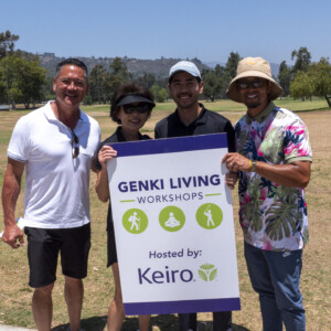 a group of people holding onto the genki living workshops sign