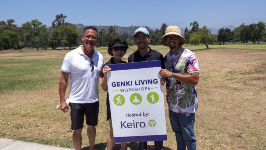 a group of people holding onto the genki living workshops sign