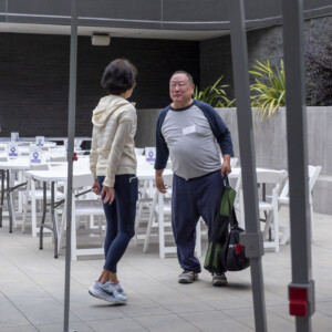 a woman in white talking to a man in gray