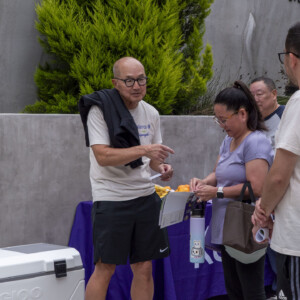 a man in beige talking with a woman in purple