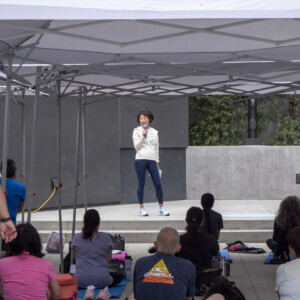 a woman in white talking to a group of people