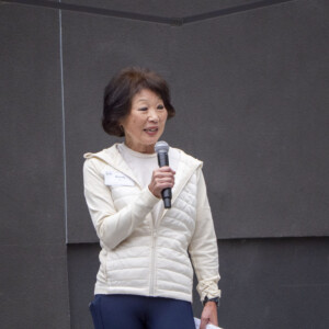 a woman in white talking to a group of people