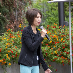 a woman in black talking to a group of people