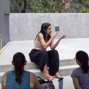 a woman in beige talking with a group of people