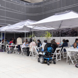 a group of people sitting under white tents