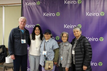 five people smiling in front of Keiro backdrop