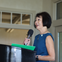 Beverly Ito talking into mic at podium