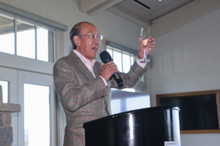 Tom Iino talking into mic doing a toast