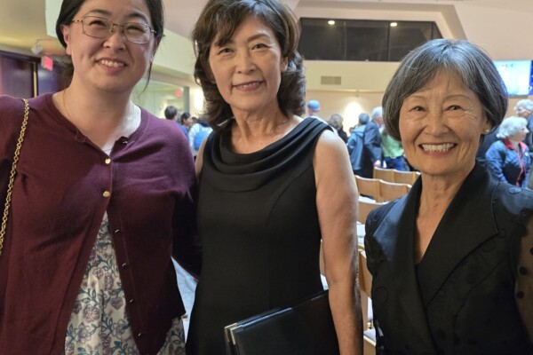 three women smiling at concert