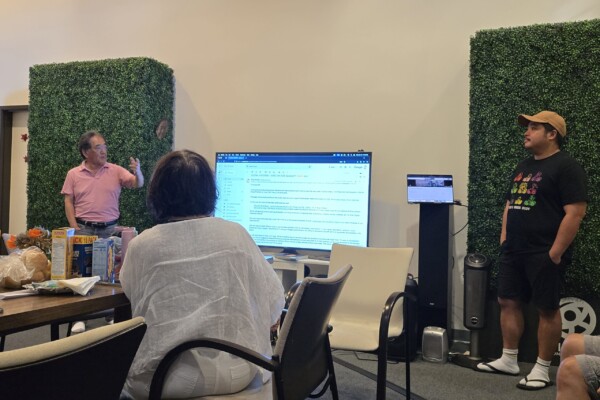 two people with a TV presenting to a group