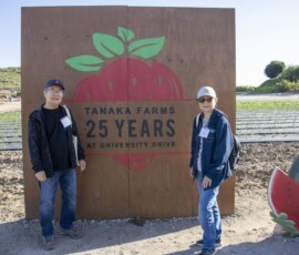 two people standing in front of Tanaka sign
