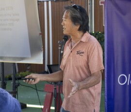 a man in a orange shirt talking