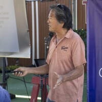 a man in a orange shirt talking
