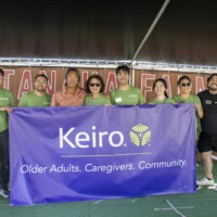group of people behind a purple banner