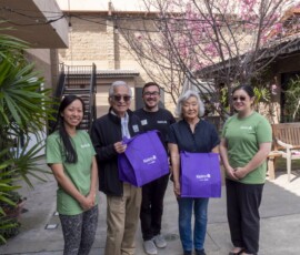 group of people holding purple bags