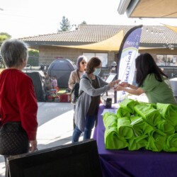 a woman handing a woman in green tshirt