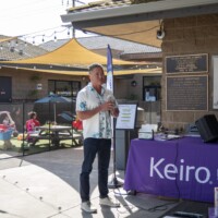a man in white shirt talking with a mic